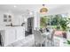 A modern kitchen dining area with a stainless steel refrigerator, white cabinets, and access to outdoor patio at 3843 Neptune Se Dr, St Petersburg, FL 33705