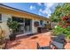 Outdoor patio with brick pavers, mature landscaping and a sliding door to indoor dining at 3843 Neptune Se Dr, St Petersburg, FL 33705