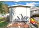 Storage shed with brick base and white metal construction with door and lock at 3843 Neptune Se Dr, St Petersburg, FL 33705
