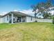 Expansive backyard with a well-maintained lawn, covered patio, and fenced perimeter at 3891 Reflection Dock Dr, Seffner, FL 33584