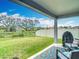 Spacious backyard with lush green grass, a covered patio area, and a view of mature trees at 3891 Reflection Dock Dr, Seffner, FL 33584