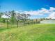 Lush backyard with expansive green space, a black metal fence, and views of a serene greenbelt at 3891 Reflection Dock Dr, Seffner, FL 33584