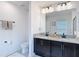 Bright bathroom featuring a double vanity with granite countertops, modern fixtures, and a tiled floor at 3891 Reflection Dock Dr, Seffner, FL 33584