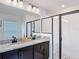 Bright bathroom with a double vanity with granite countertops, a framed mirror, and a walk-in shower at 3891 Reflection Dock Dr, Seffner, FL 33584
