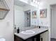 Bathroom with granite countertop, white sink, black fixtures, decorative art and a shelf at 3891 Reflection Dock Dr, Seffner, FL 33584