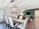 A dining room with an adjacent living room featuring a green accent wall and ceiling fan at 3891 Reflection Dock Dr, Seffner, FL 33584