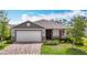 Charming single-story home boasts a two-car garage, brick paver driveway, manicured landscaping, and colorful accents at 3891 Reflection Dock Dr, Seffner, FL 33584
