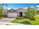 Charming single-story home boasts a two-car garage, brick paver driveway, manicured landscaping, and colorful accents at 3891 Reflection Dock Dr, Seffner, FL 33584