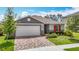 Charming single-story home boasts a two-car garage, brick paver driveway, manicured landscaping, and colorful accents at 3891 Reflection Dock Dr, Seffner, FL 33584