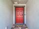 Welcoming front entryway with a vibrant red door and textured walls at 3891 Reflection Dock Dr, Seffner, FL 33584