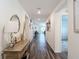 Inviting hallway with wood flooring, console table, decorative mirror, and views into other rooms at 3891 Reflection Dock Dr, Seffner, FL 33584