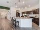 Bright kitchen with a granite island, stylish bar stools, and dark wood cabinets at 3891 Reflection Dock Dr, Seffner, FL 33584