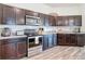 A kitchen with dark cabinets, stainless steel appliances, and granite countertops at 3891 Reflection Dock Dr, Seffner, FL 33584