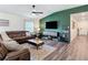 Inviting living room with a stylish accent wall, cozy sectional, and modern entertainment center at 3891 Reflection Dock Dr, Seffner, FL 33584