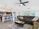 Open-concept living room flows into the kitchen, featuring a comfortable sectional and modern ceiling fan at 3891 Reflection Dock Dr, Seffner, FL 33584