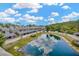 Aerial view of a residential community with a beautiful lake and surrounding landscape at 4047 Gauge Line Loop, Tampa, FL 33624