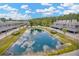Stunning aerial view of community featuring modern townhomes, carports, and a scenic pond with fountain at 4047 Gauge Line Loop, Tampa, FL 33624