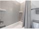 Detail of a bathtub and shower combination featuring neutral gray tiles and hardware at 4047 Gauge Line Loop, Tampa, FL 33624