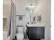 Modern bathroom with combined shower-tub featuring gray tiles, matching towels, and black hardware at 4047 Gauge Line Loop, Tampa, FL 33624