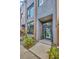 Contemporary townhouse entrance featuring a modern glass door and manicured plants at 4047 Gauge Line Loop, Tampa, FL 33624