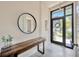 Bright foyer with modern wood console table and decorative round mirror at 4047 Gauge Line Loop, Tampa, FL 33624