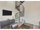Bright living room featuring a modern spiral staircase and sleek entertainment center at 4047 Gauge Line Loop, Tampa, FL 33624