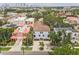Aerial view of a multi-story white home with a brown roof nestled among lush greenery and other colorful homes at 412 S Albany Ave # 2, Tampa, FL 33606
