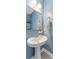 Charming powder room featuring a pedestal sink, decorative mirror, and soft blue walls, creating a serene and inviting space at 412 S Albany Ave # 2, Tampa, FL 33606