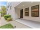 Inviting front porch with a black door, manicured bushes, and recessed lighting at 412 S Albany Ave # 2, Tampa, FL 33606