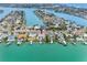 Aerial view of the property featuring a private dock, waterfront access, pool and lush landscaping at 440 115Th Ave, Treasure Island, FL 33706