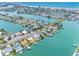 An aerial view showcases waterfront homes with private docks on a canal leading to the ocean at 440 115Th Ave, Treasure Island, FL 33706