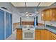 View of the kitchen showcasing a white oven and stove top in an open space with blue cabinets at 508 E Brentridge, Brandon, FL 33511
