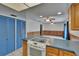 View of the kitchen showcasing a white oven and stove top in an open space with blue cabinets at 508 E Brentridge, Brandon, FL 33511