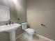 Bathroom with a pedestal sink, and a toilet with tiled floors at 5636 Whitehead St, Bradenton, FL 34203