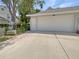 Exterior shot of a two-car garage with a paved driveway and mature trees at 5636 Whitehead St, Bradenton, FL 34203