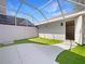 Outdoor patio features artificial grass, a white privacy wall, a caged roof, and a storage space at 5636 Whitehead St, Bradenton, FL 34203