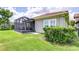 Exterior view of the screened-in patio and well-manicured backyard at 5728 Watercolor Dr, Lithia, FL 33547
