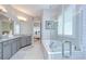 Bright bathroom featuring double vanity, soaking tub with glass shower, and neutral color palette at 5728 Watercolor Dr, Lithia, FL 33547