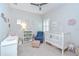 Cute Bedroom featuring a crib, bookshelf, and changing table, creating a cozy and inviting space at 5728 Watercolor Dr, Lithia, FL 33547