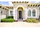 Charming home entrance with an arched doorway, white columns, and manicured landscaping at 5728 Watercolor Dr, Lithia, FL 33547