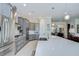 Bright kitchen features stainless steel appliances, gray cabinets, and a large quartz island with seating at 5728 Watercolor Dr, Lithia, FL 33547