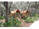 Charming wooden playground with a slide and climbing areas nestled amongst the trees at 5728 Watercolor Dr, Lithia, FL 33547