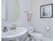 Powder room featuring a pedestal sink, round mirror, and neutral color palette at 5728 Watercolor Dr, Lithia, FL 33547