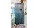 Close-up of the bathroom's shower showing glass enclosure and blue and white tile work at 650 70Th Ave, St Pete Beach, FL 33706
