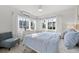Well-lit bedroom with large windows, comfortable seating, and a stylish ceiling fan at 650 70Th Ave, St Pete Beach, FL 33706
