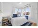 Cozy bedroom featuring white walls, coastal decor, and a comfortable bed with blue accents and sunlight streaming through the windows at 650 70Th Ave, St Pete Beach, FL 33706