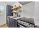 Well-equipped kitchen featuring a range, open shelving, and built-in washer/dryer at 650 70Th Ave, St Pete Beach, FL 33706