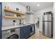 Efficient kitchen with sleek appliances, floating shelves, and integrated washer/dryer at 650 70Th Ave, St Pete Beach, FL 33706