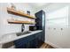 Charming kitchenette featuring modern blue cabinets, open wooden shelves, and a convenient sink and microwave area at 650 70Th Ave, St Pete Beach, FL 33706