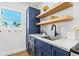 Compact laundry area featuring modern appliances, shelving, and bright natural light at 650 70Th Ave, St Pete Beach, FL 33706